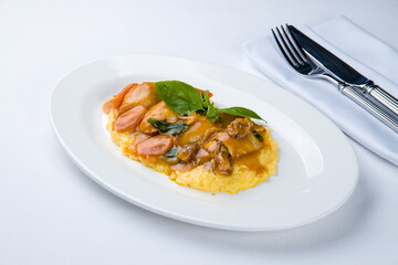 Roasted squid and mashed potatoes on a white plate
