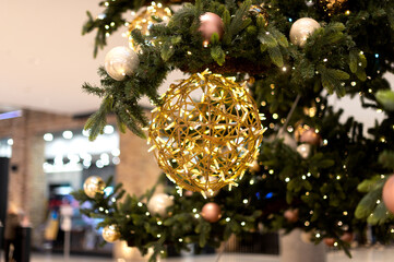 Beautiful golden bauble hanging from a Christmas tree