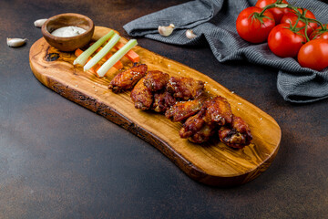Chicken wings with blue cheese sauce on dark brown table