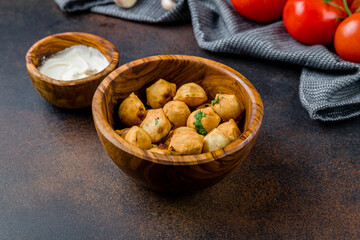 fried dumplings with sauce on dark brown table