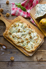 pizza with pear and Gorgonzola on Roman dough, pinsa on wooden table top view