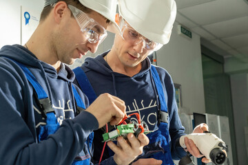 Electricians check motherboard and work with soldered cables in laboratory. Technicians check...