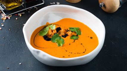 Tomato cream soup with shrimps, black caviar parsley and olive oil.