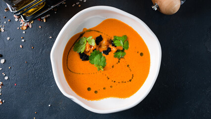 Fresh tomato cream soup with shrimps, black caviar parsley and olive oil.