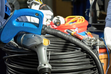 Electricians repair plugs for charging EV with alternative energy on stations. Technicians assemble made charging plugs in workshop