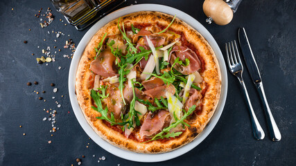 Italian pizza with ham, parmesan, tomato sauce, arugula and spices. - obrazy, fototapety, plakaty