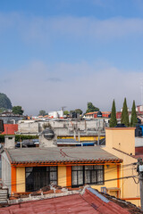 Fototapeta premium Beautiful sunny day in mountain city in Mexico. The famous tiled roofs of the city.