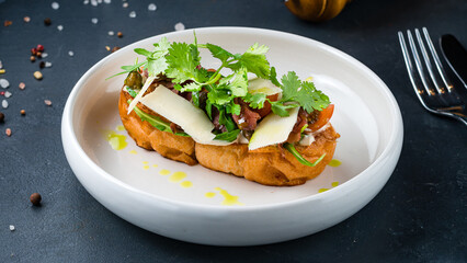 Italian food bruschetta with beef slices, capers, cherry tomatoes, parmesan cheese, parsley.