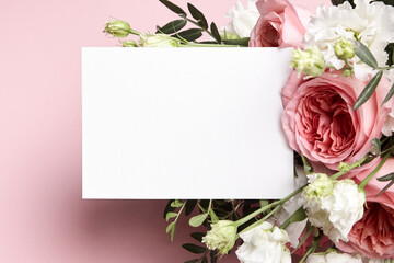 Obraz na płótnie Canvas Holiday greeting card mockup with flowers on light pink background, top view, flat lay. White wedding invitation mockup and floral decor