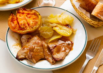 Appetizing pork in sauce with baked potatoes and grilled tomato