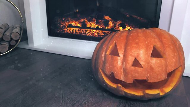 Pumpkin smiling face by the burning fireplace