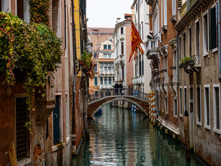 Fototapeta na wymiar Typical canal of Venice with San Marco flag