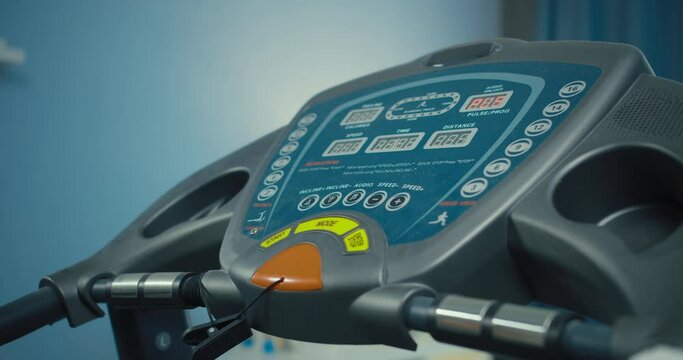 Man athlete on a treadmill set up parametrs trining on console control. Close-up of male in home gym