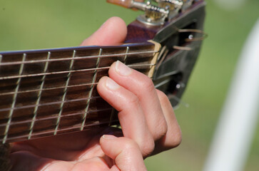 woman's hand making a chord on the guitar, close up shot