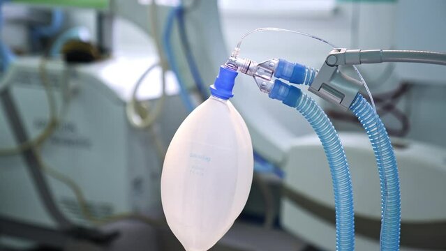 Moving ambu bag with connected tubes hanging in the surgery room. Close up. Blurred background.