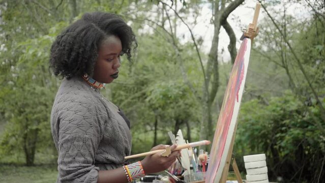 young woman leisurely painting in nature
