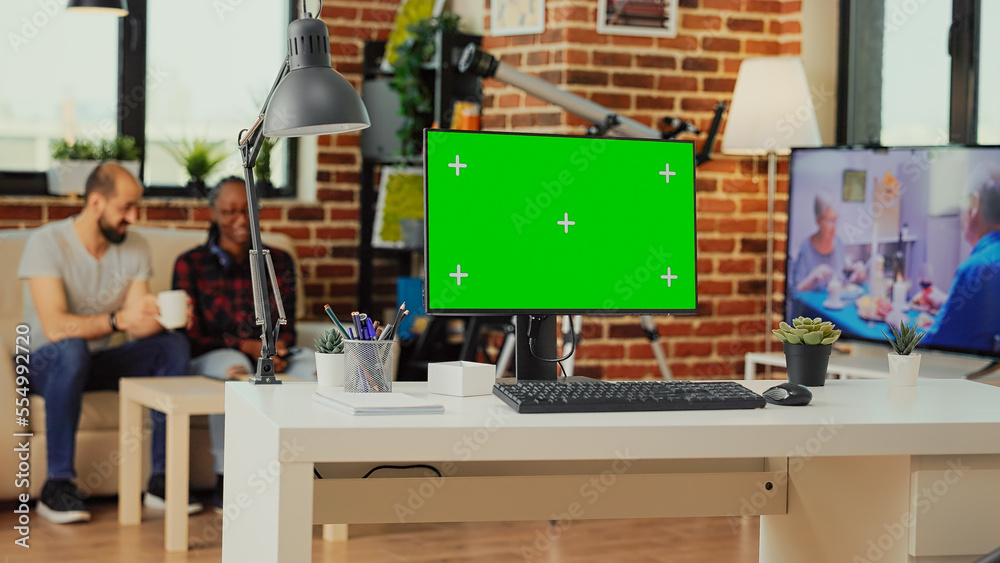 Poster empty workspace table with greenscreen display on computer used to work on freelance in living room 