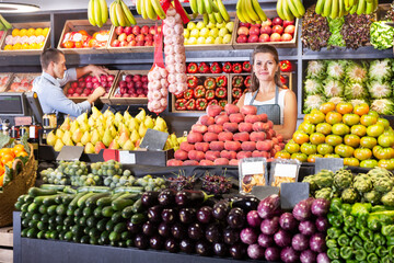 Fototapeta na wymiar Portrait of male and female experienced shop assistants working in fruit and vegetable shop