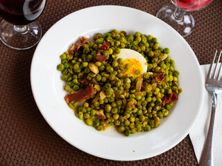 Delicious dish of green peas with ham. Decorated with boiled egg, cut in half..