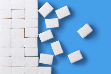 White sugar cubes, isolated on blue background, view from above