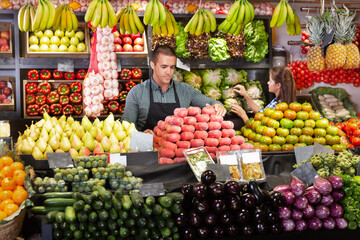 Fototapeta na wymiar Portrait of male and female shop assistants working responsibly in a fruit and vegetable shop