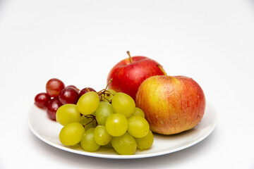 Naklejka na ściany i meble Close up of apples and grapes on a plate