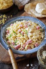 Italian Cuisine. Stortini pasta with fresh ham cubes, parmesan cheese and glass of white wine