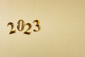 New year 2023 on golden background. Happy new year 2023 background, new year holidays card with golden sparkle. Goals, resolutions, action concept. Copy space