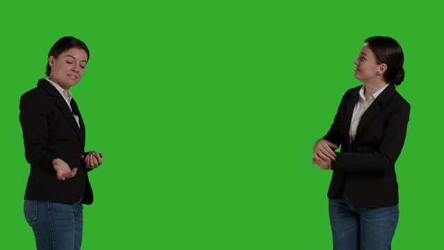 Professional manager pointing aside to show advertisement over greenscreen studio backdrop, creating example ad on blank copyspace. Young adult with suit showing ad icon in front of camera.
