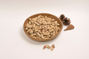 껍질있는 땅콩, 나무 접시에 담겨있는. 흰배경.