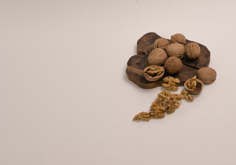 나무 접시 위에 껍질있는 호두 열매. 흰배경.