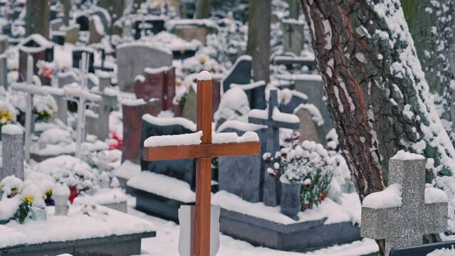 Wooden Burial Crucifix Cross on Christian Cemetery Covered in Snow on Cold Wintertime Day