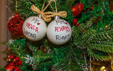 Close up of white Mr never wrong and Mrs always write New Year balls on a Christmas tree