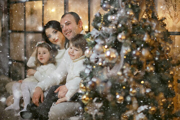 family with small children new year tree, december holidays at home