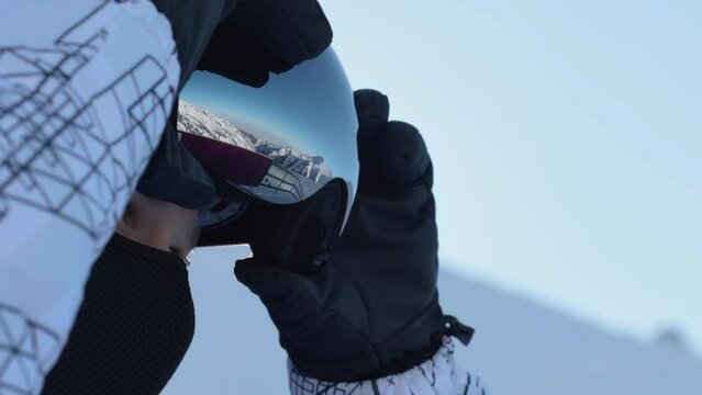 Young man in helmet wearing glasses on the background of sky with sun on blurred mountain like a background. slowmotion.