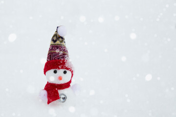 A happy snowman stands on a winter landscape. Snow background. Winter fairy tale