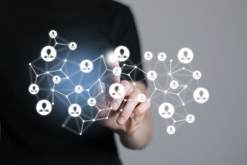 Obraz premium Human resources manager pointing at virtual network chain with person icons. Human capital and teambuilding concept.