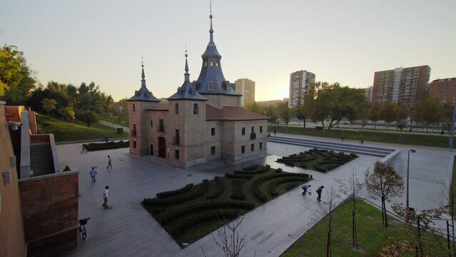 Chapel of the Virgin of the Harbour beautiful monastery churchcenter of Madrid attached to the Manzanares river the Royal Palace capital of Spain on sunset day  autumn colors with skateboarders around