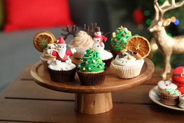 Many different Christmas cupcakes on wooden table indoors