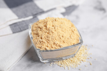 Sesame flour in glass bowl on white marble table