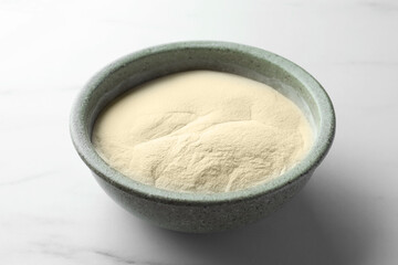 Bowl of agar-agar powder on white marble table