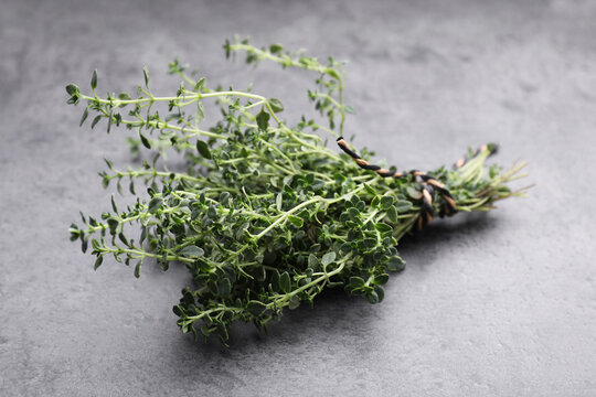Bunch of aromatic thyme on grey table, closeup. Fresh herb