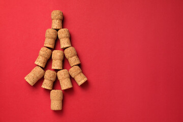 Christmas tree made of wine corks on red background, top view. Space for text