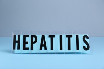 Word Hepatitis on light blue table. Medical issue