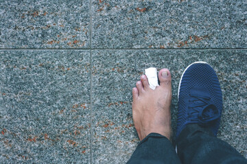 Closeup of man left foot with a wounded toe healed with band aid for medical care