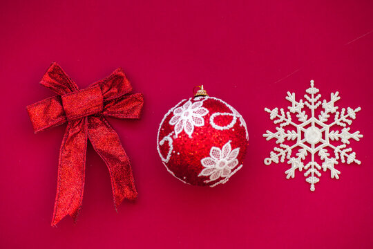 Christmas composition of the color Viva Magenta. Color of the year 2023. Magenta Christmas ball with Christmas snowflake and bow, selective focus