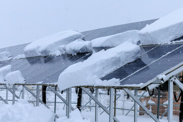 雪が積もった太陽光パネル　発電　雪国　冬
