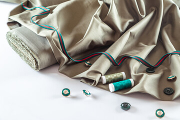 olive fabric, buttons and spools of thread