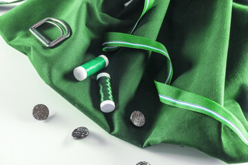 green fabric, buttons and spools of thread