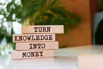 Wooden blocks with words 'Turn Knowledge Into Money'.